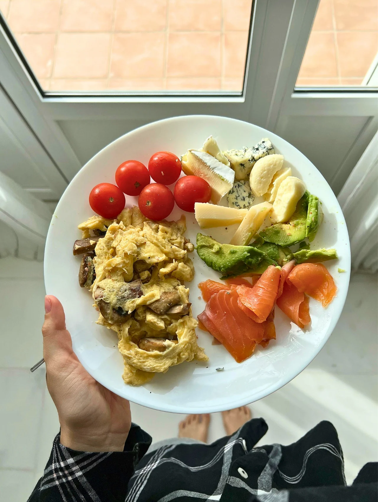 Scrambled eggs with mushrooms, smoked salmon, avocado, cheese, and cherry tomatoes inspired by easy breakfast recipes