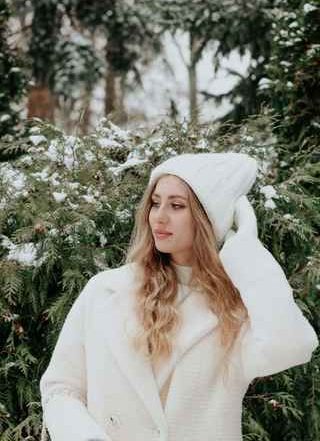 model using a white cozy coat with an entirely white outfit