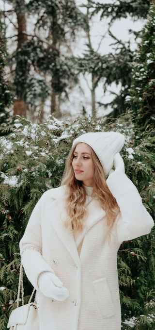 model using a white cozy coat with an entirely white outfit