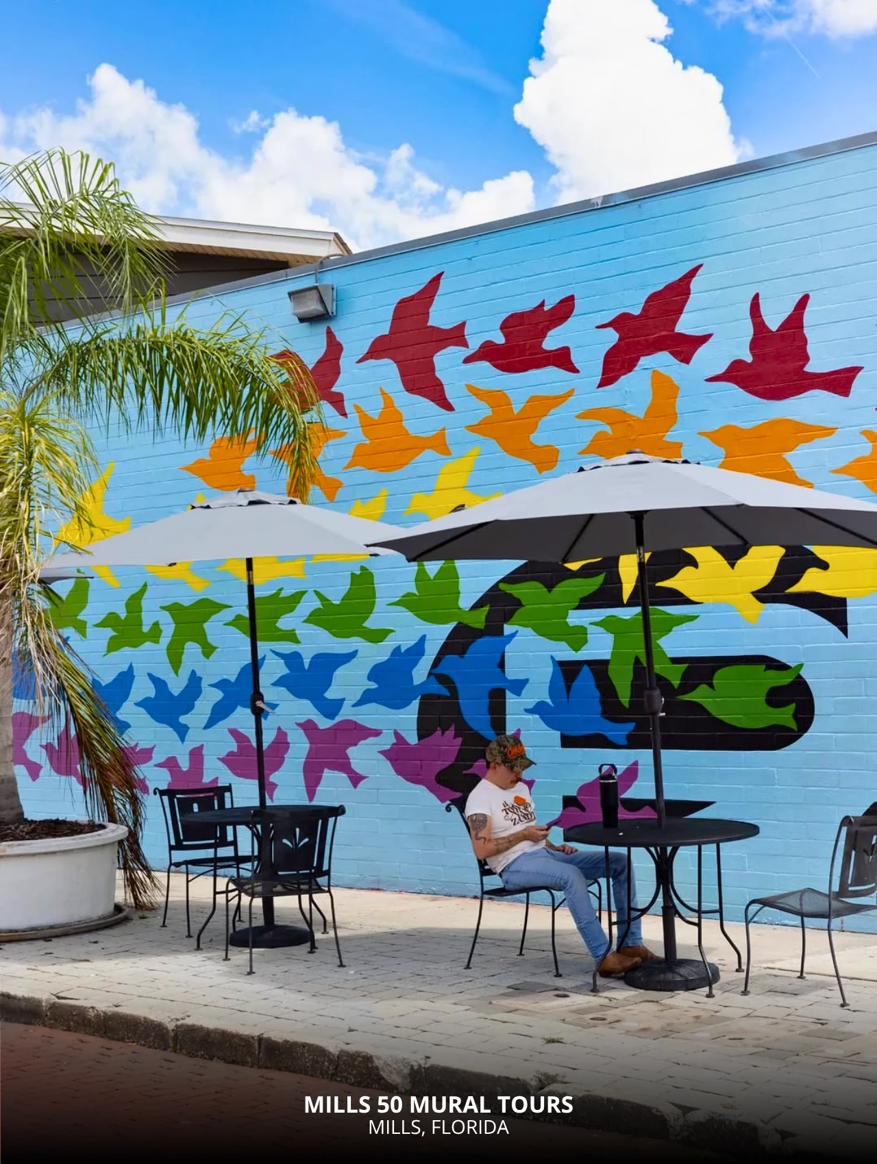 Colorful mural wall at Mills 50 with people seated – free things to do in Orlando