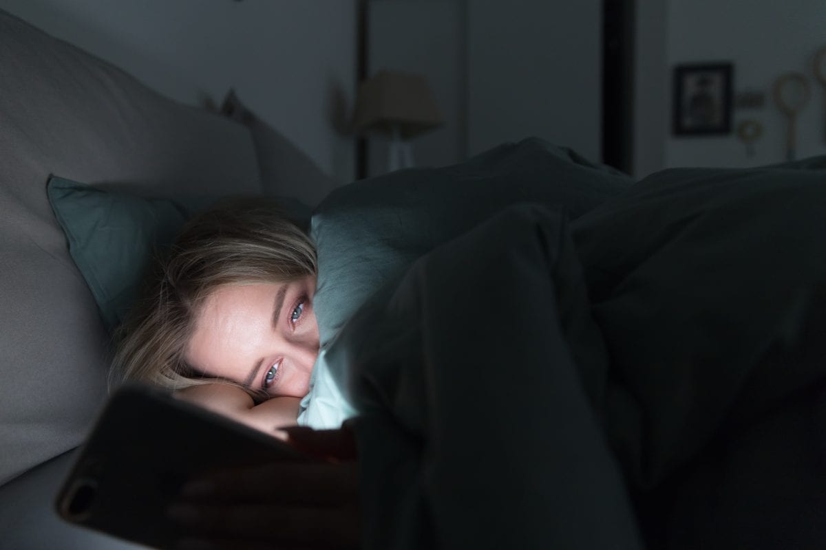 Woman Using Mobile Phone in Bed