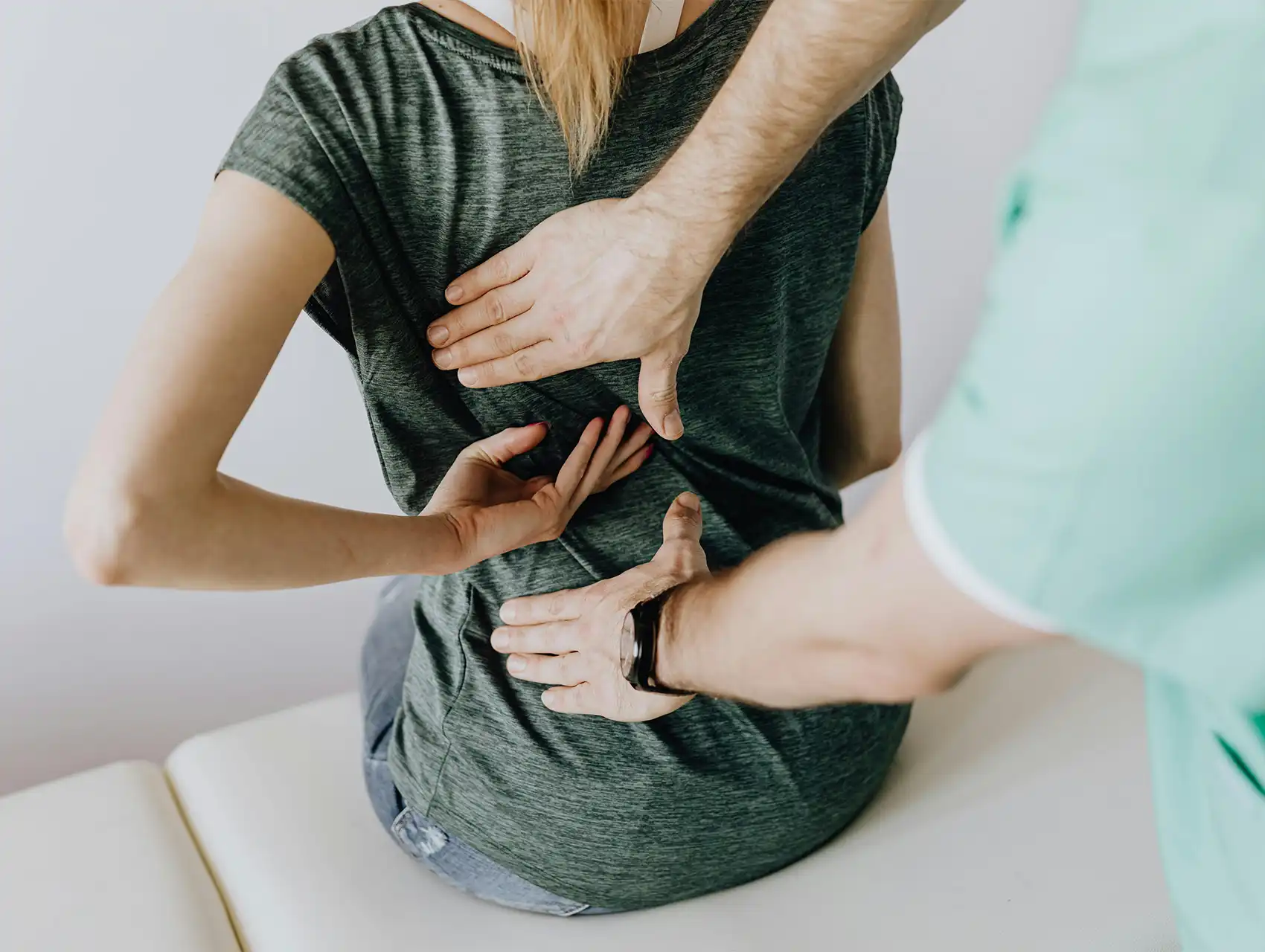 Doctor examining a patient’s back during a health consultation, highlighting posture and concerns tied to the question: do waist trainers work.