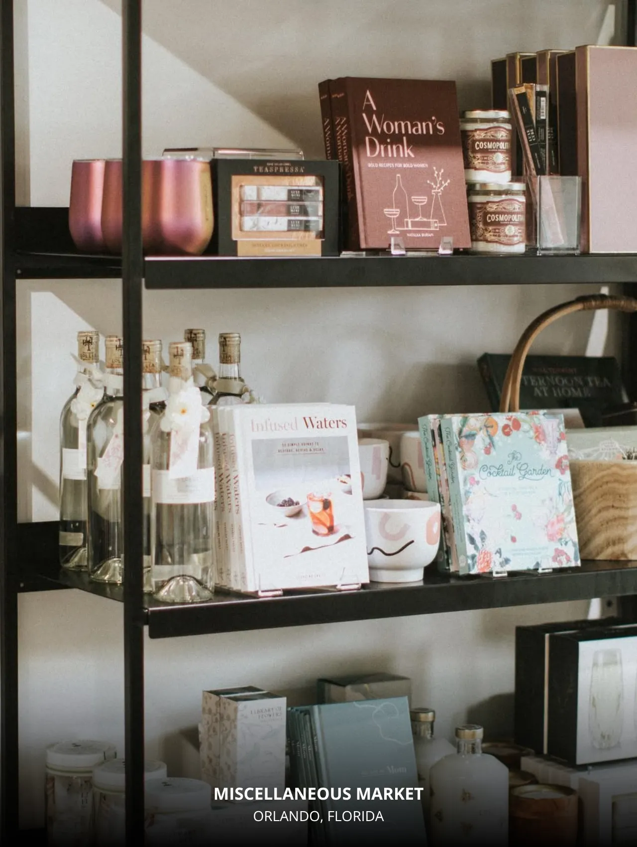 Shelf display at Miscellaneous Market Orlando Florida featuring cocktail books, infused water recipes, and artisanal gift items.