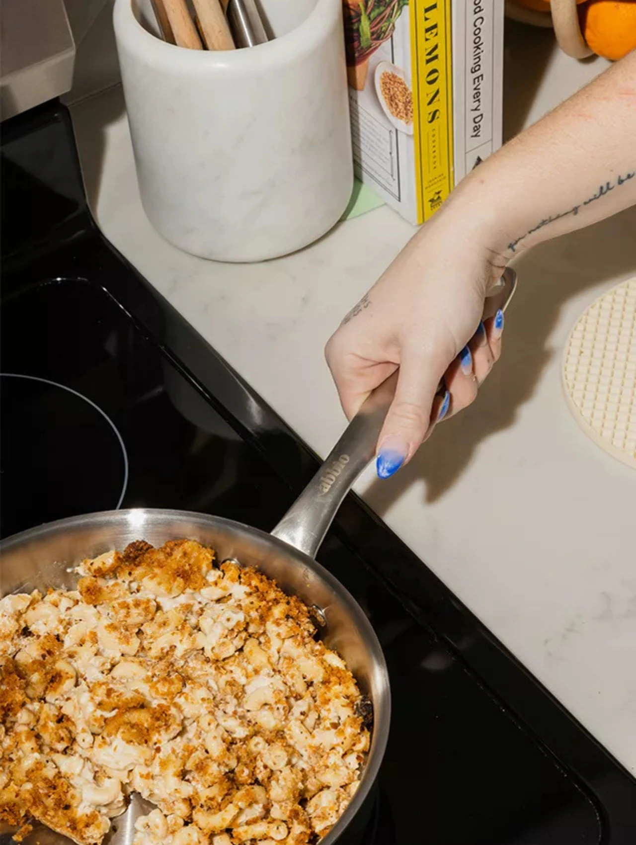 Person cooking boujee mac and cheese on the stovetop as part of a cozy Christmas Dinner side dish.