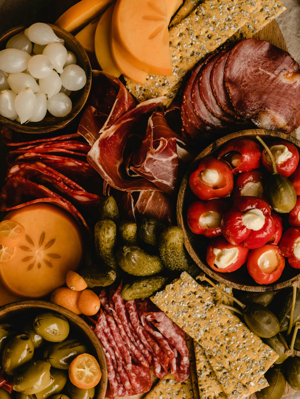 Festive charcuterie board filled with meats, cheeses, olives, pickles, and crackers for a Christmas Dinner appetizer spread.