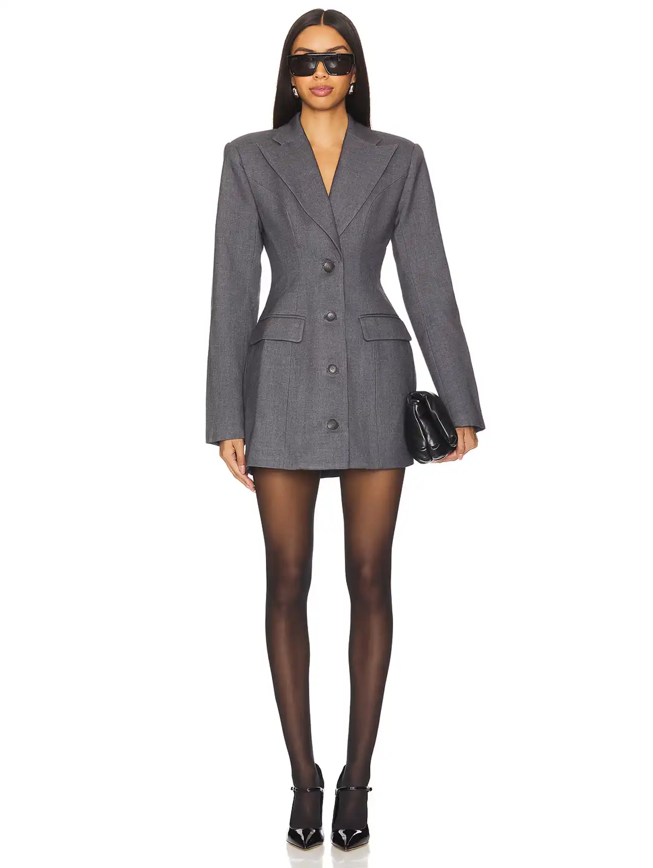 Woman wearing a grey blazer dress with black tights and heels, styled with sunglasses and clutch bag