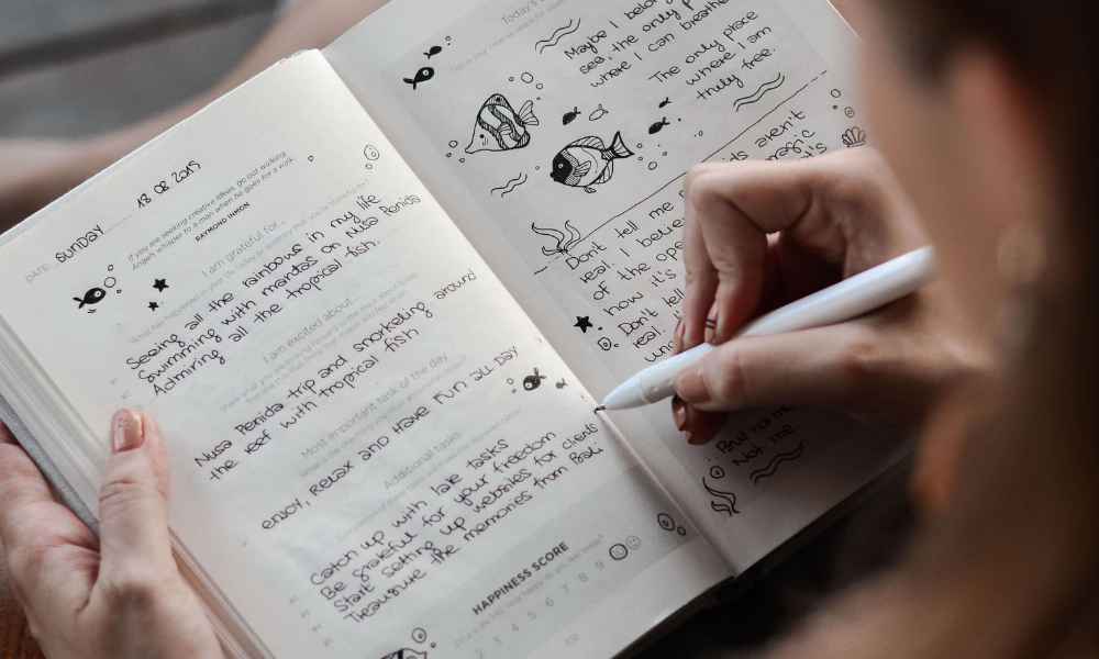 women writing and doing doodles on notebook