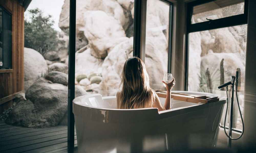 Women in a bath holding a glass of wine 