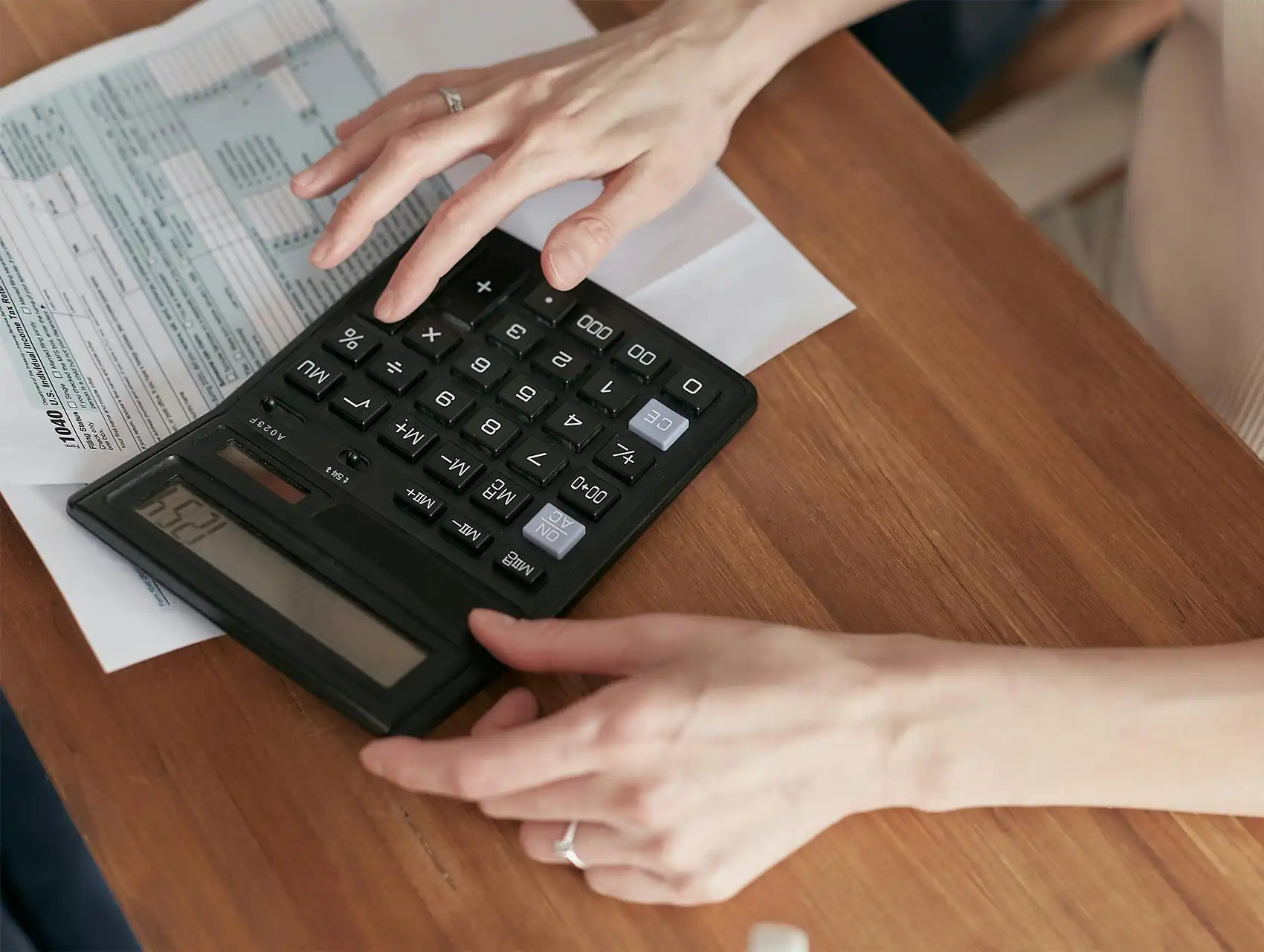 Manos con calculadora, ejemplo de violencia económica como uno de los tipos de violencia contra la mujer