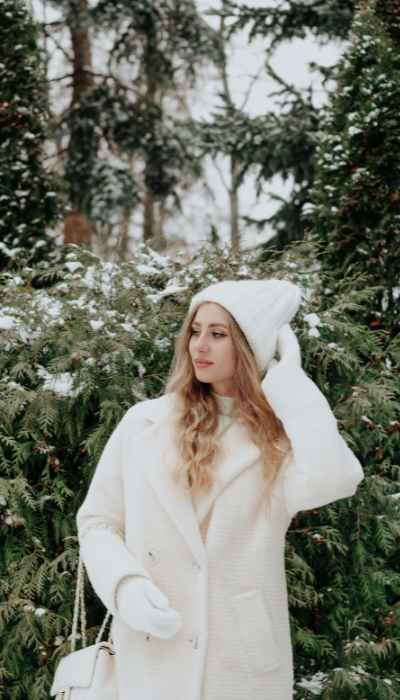 model using a white cozy coat with an entirely white outfit