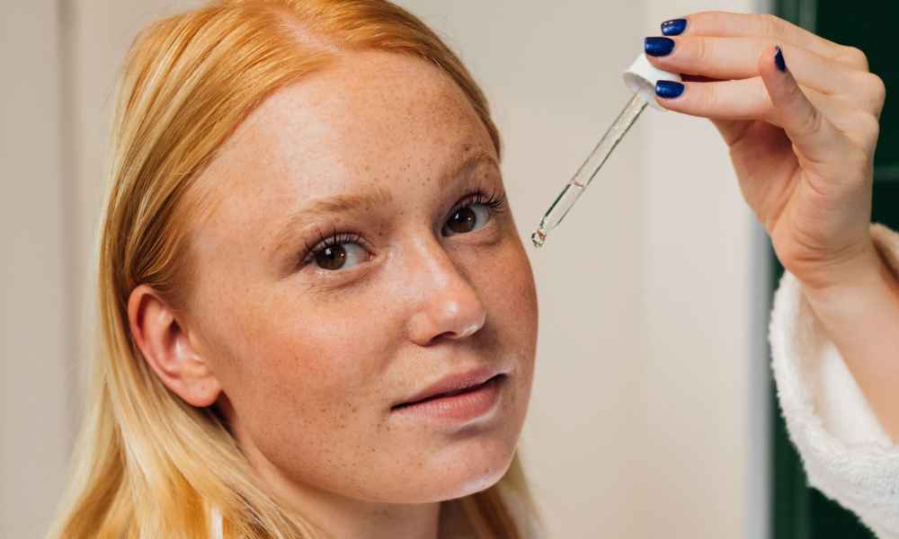 Woman putting on a serum on her face