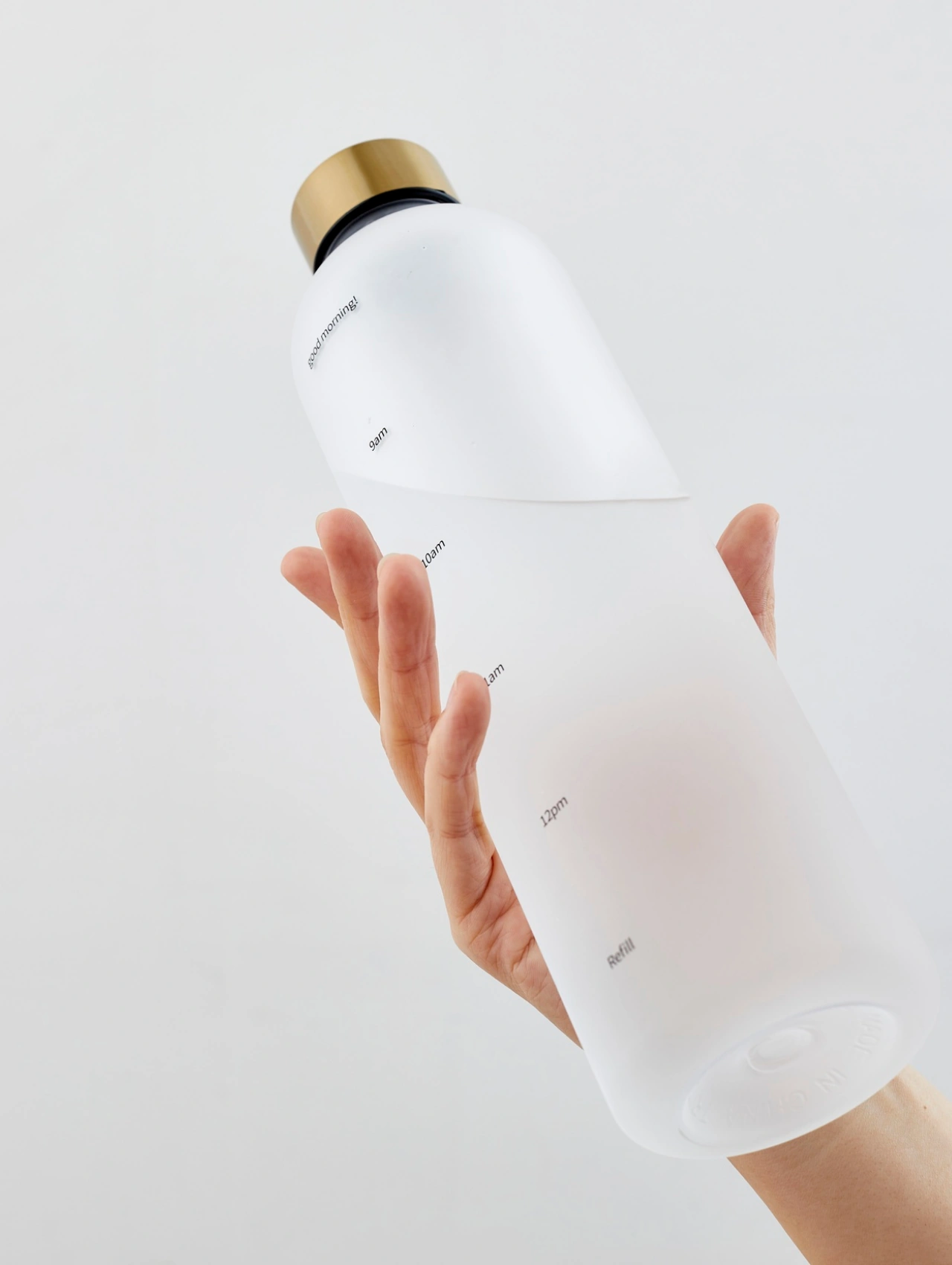 A reusable water bottle held in hand, an essential hydration item for gym essentials for beginners.