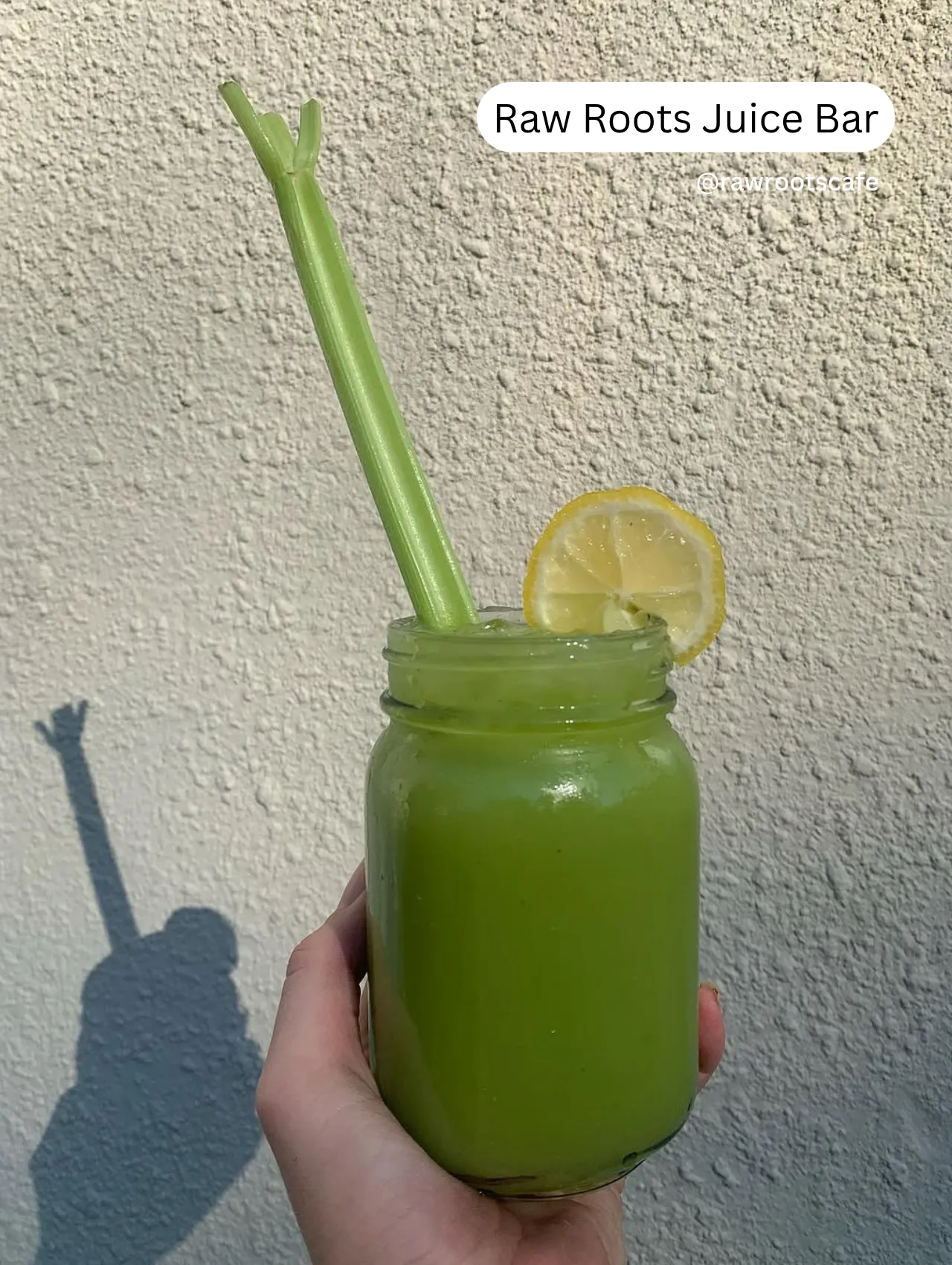 Smoothies in Orlando – fresh green smoothie in a mason jar with a celery stick and lemon slice from Raw Roots Juice Bar, promoting healthy drinks in Orlando.