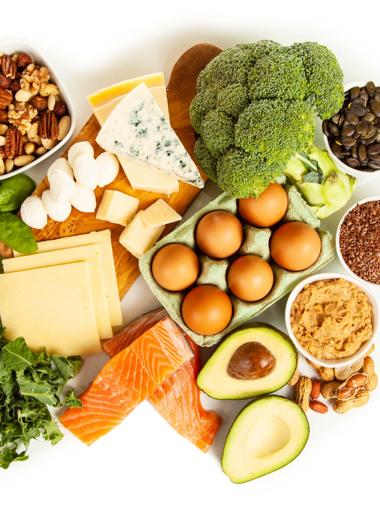 Foods you can eat on a keto diet plan including eggs, salmon, avocado, cheese, nuts, and vegetables.