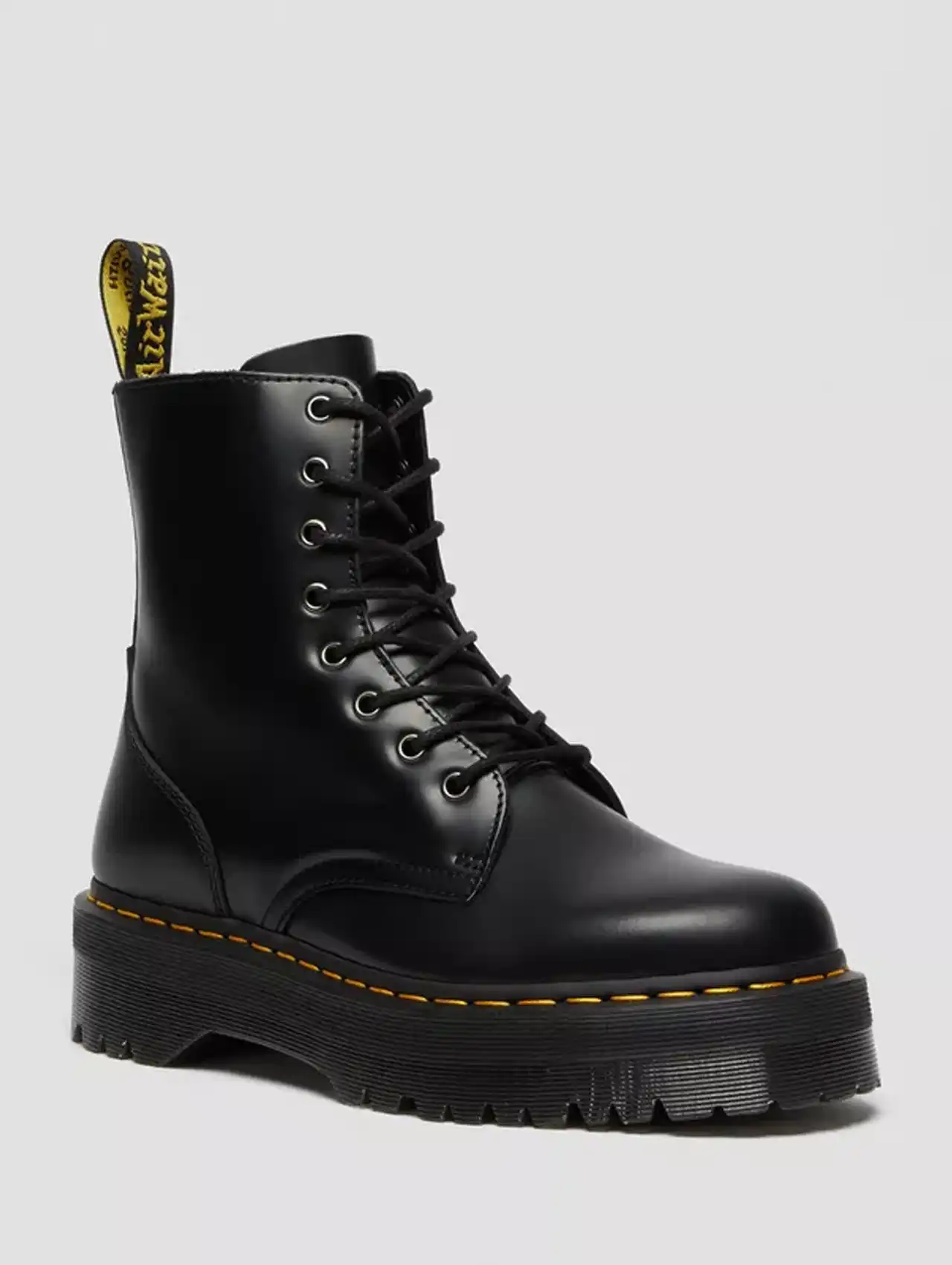 Botas de invierno para mujer estilo Dr. Martens en color negro con suela gruesa y costura amarilla.