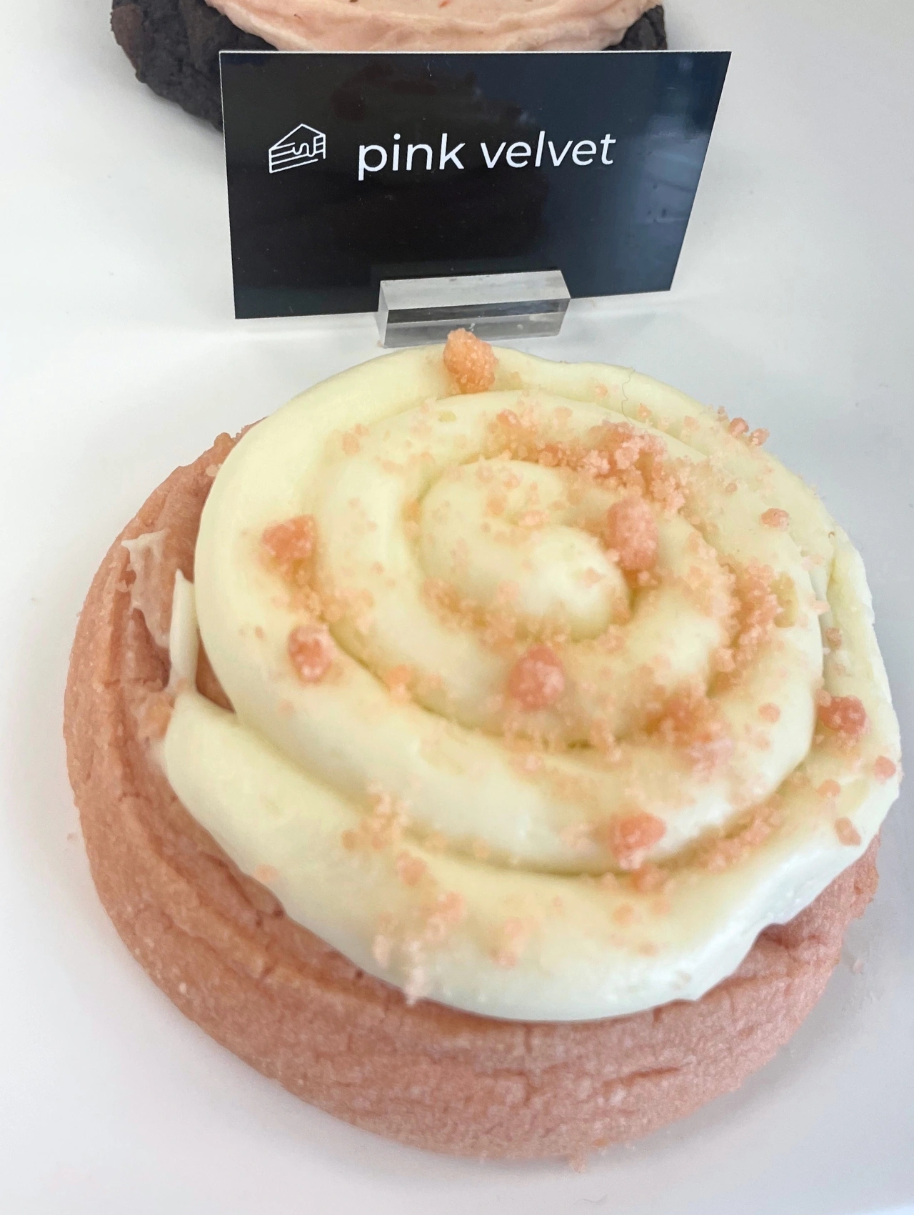 Pink Velvet cookie topped with swirled cream-cheese frosting – Crumbl Cookies Orlando