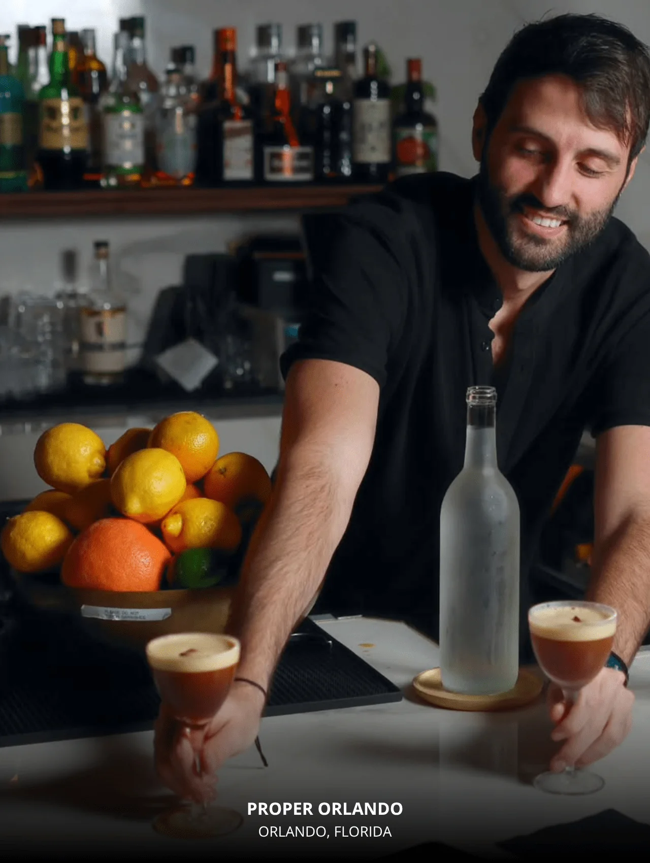 Bartender at Proper Orlando serving espresso martinis with citrus decor in background — part of 6 restaurants with great cocktails in Orlando.