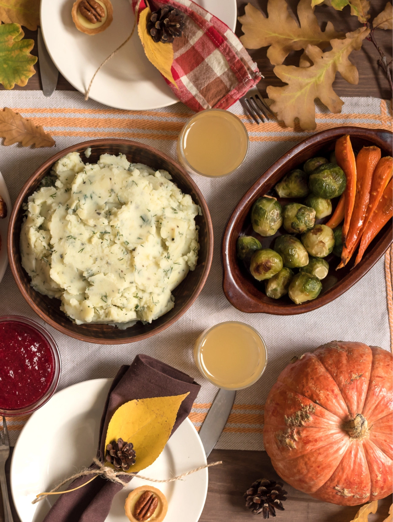 Festive Thanksgiving table with mashed potatoes, roasted veggies, and pumpkin — part of a vegan Thanksgiving Menu.