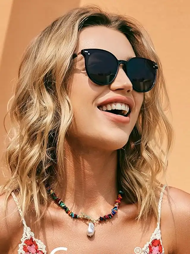 a woman wearing sunglasses and smiling