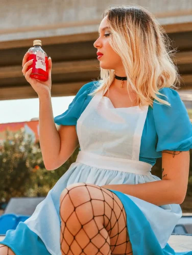 Alice in Wonderland costume with blue dress and “Drink Me” bottle, most popular halloween costumes