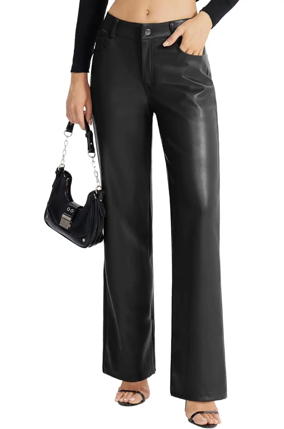 Close-up of black faux leather pants paired with a small handbag and strappy heels.