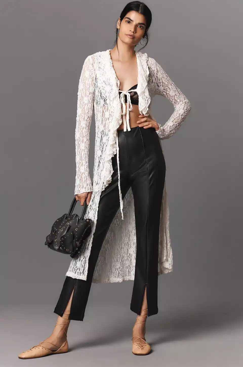 Model wearing split-hem faux leather pants with lace cardigan and bralette.