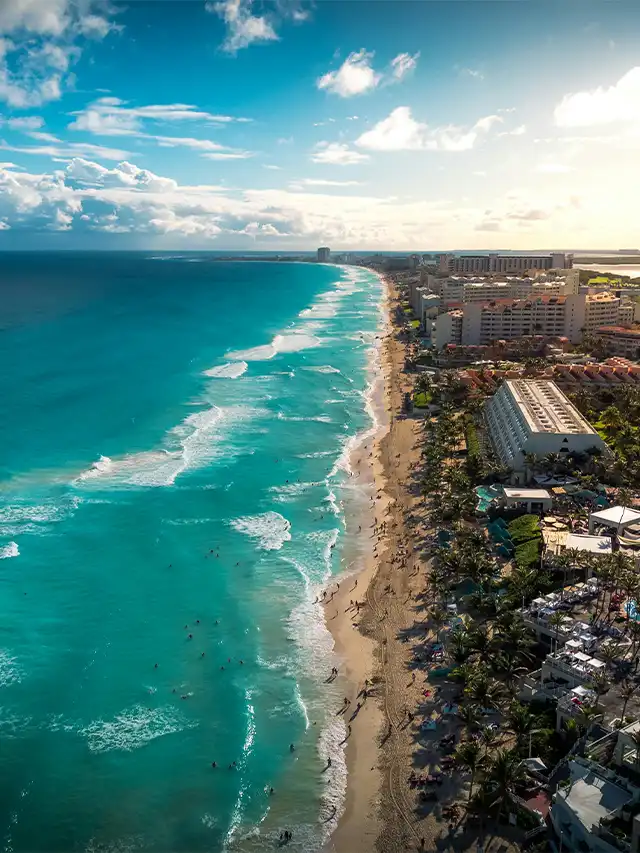 a beach with buildings and a body of water