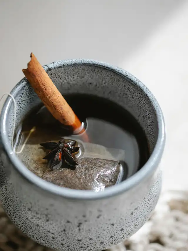 a cup of water with a cinnamon stick and a starfish