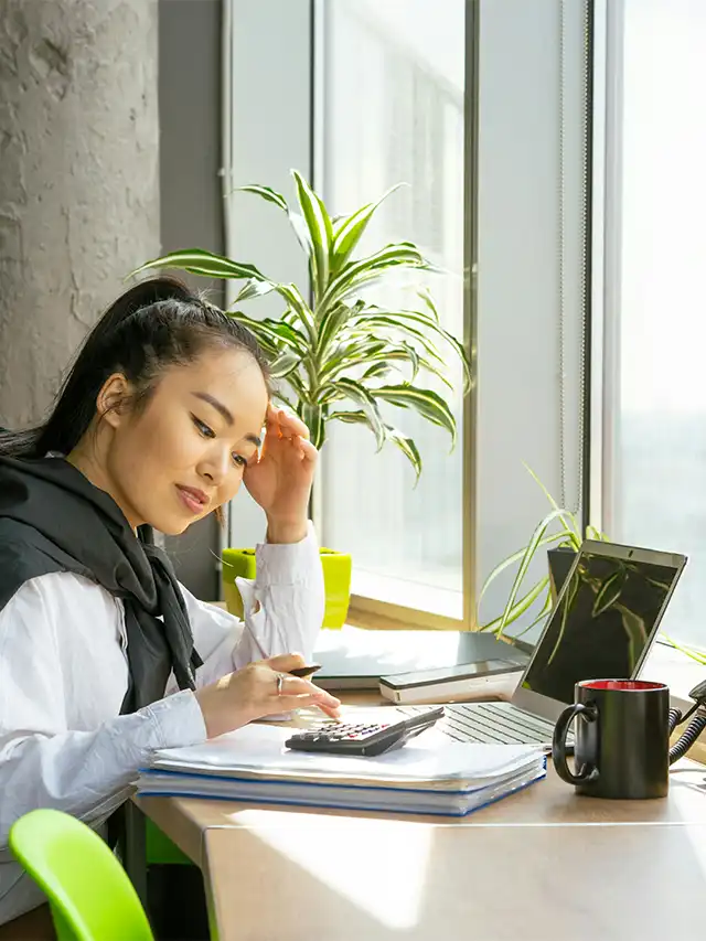 a woman looking at a calculator