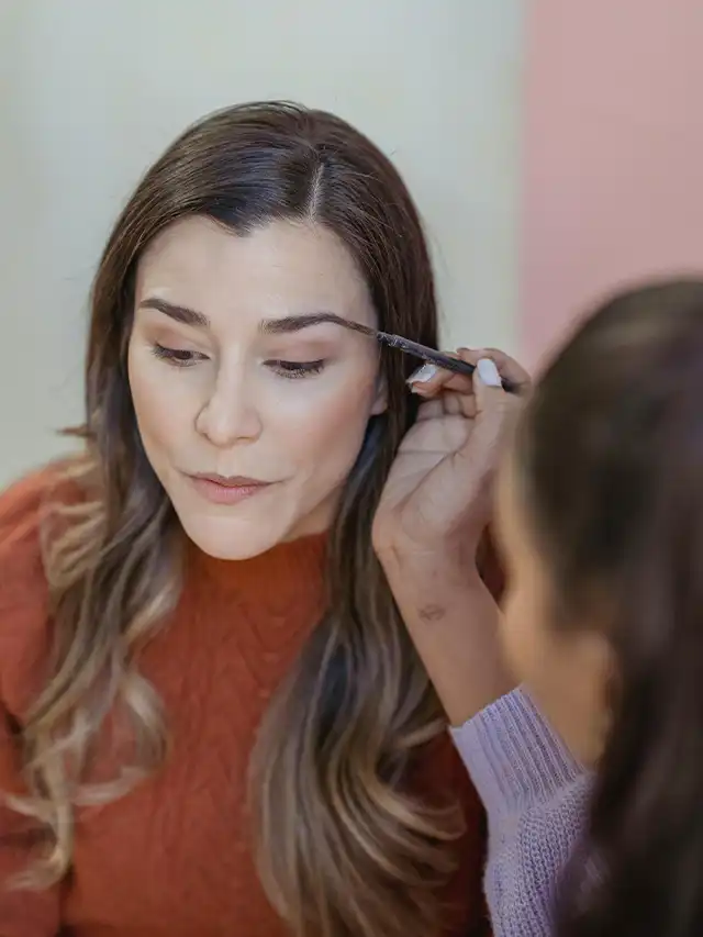a woman getting her makeup done