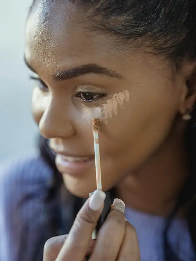a woman applying foundation on her face