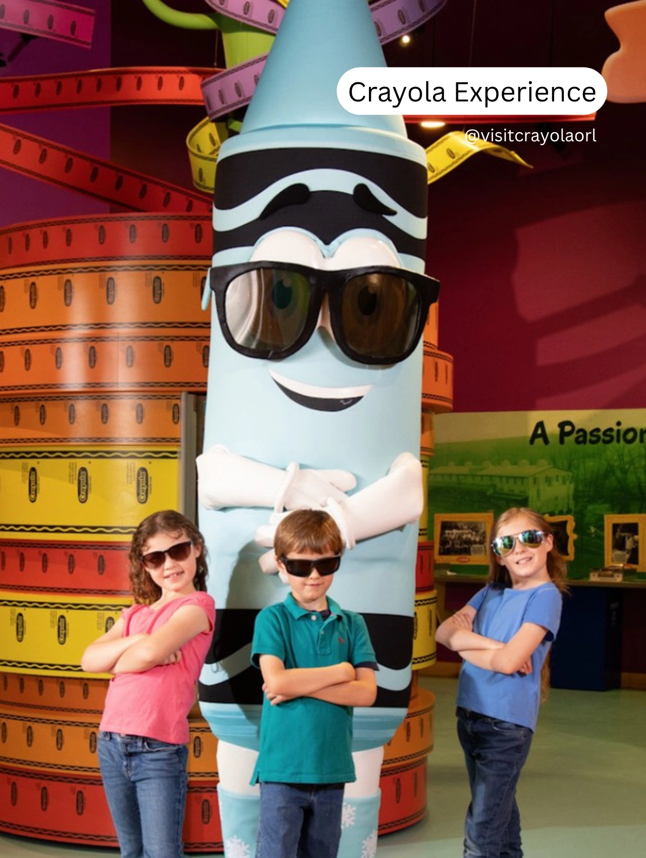Children posing with a giant crayon mascot at Crayola Experience, one of the best things to do in Orlando besides the theme parks.