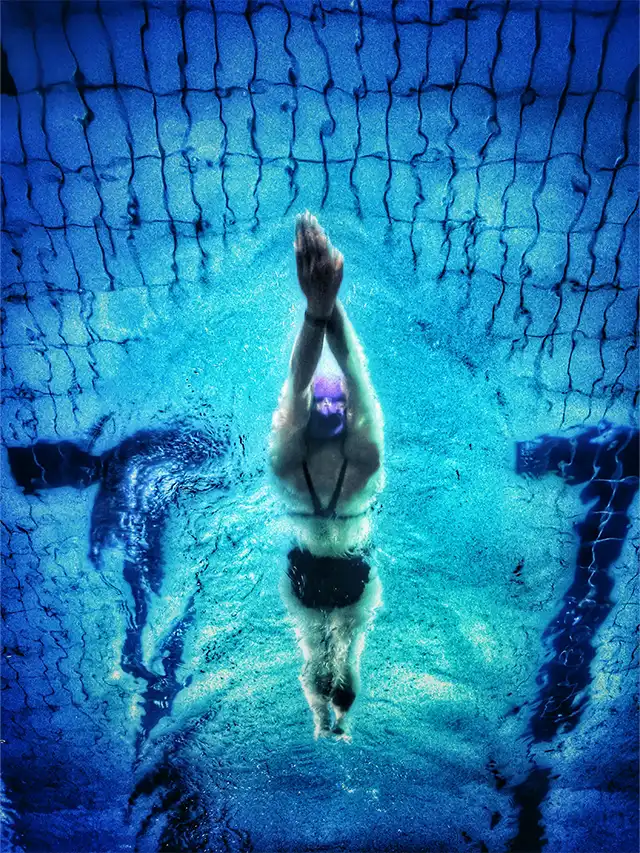a person swimming underwater with their hands up