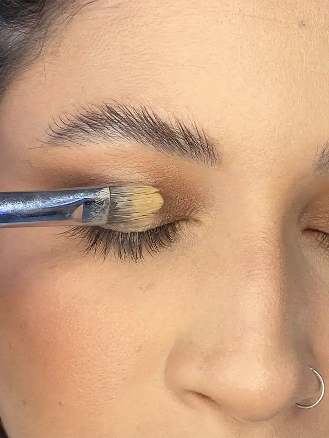 a woman applying makeup on her eyes