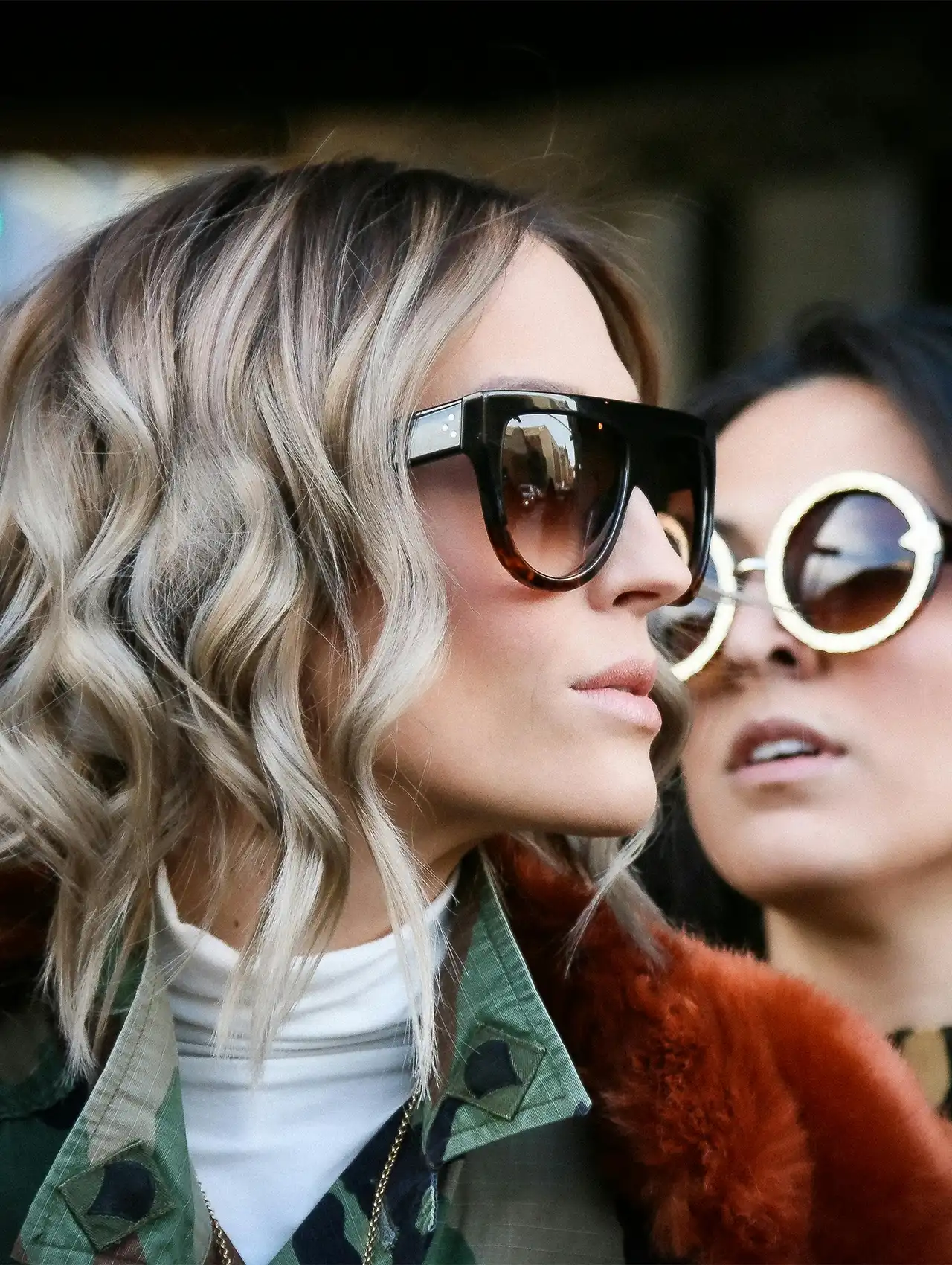 Stylish woman in sunglasses wearing layered fall outfit with camouflage and fur details, fall clothing for women