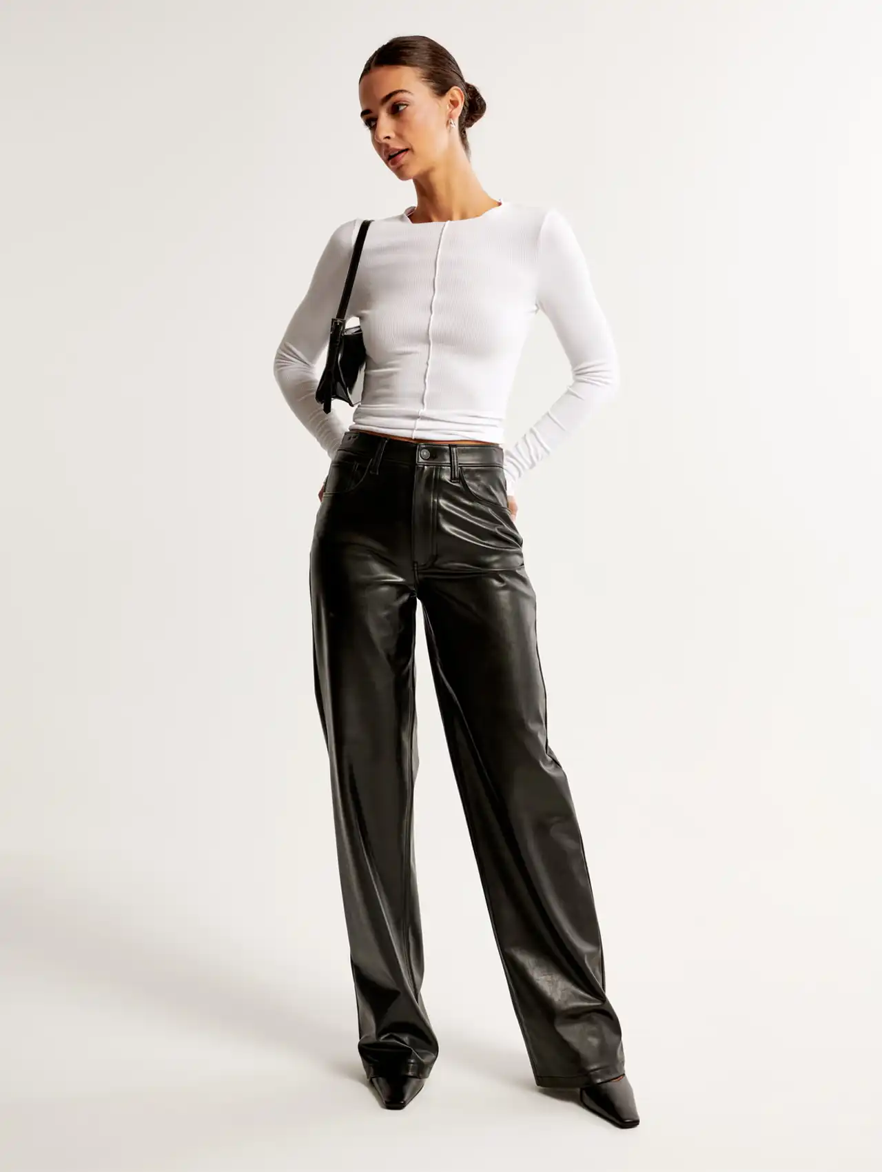 Woman wearing black faux leather wide leg pants with a white long sleeve top, fall clothing for women
