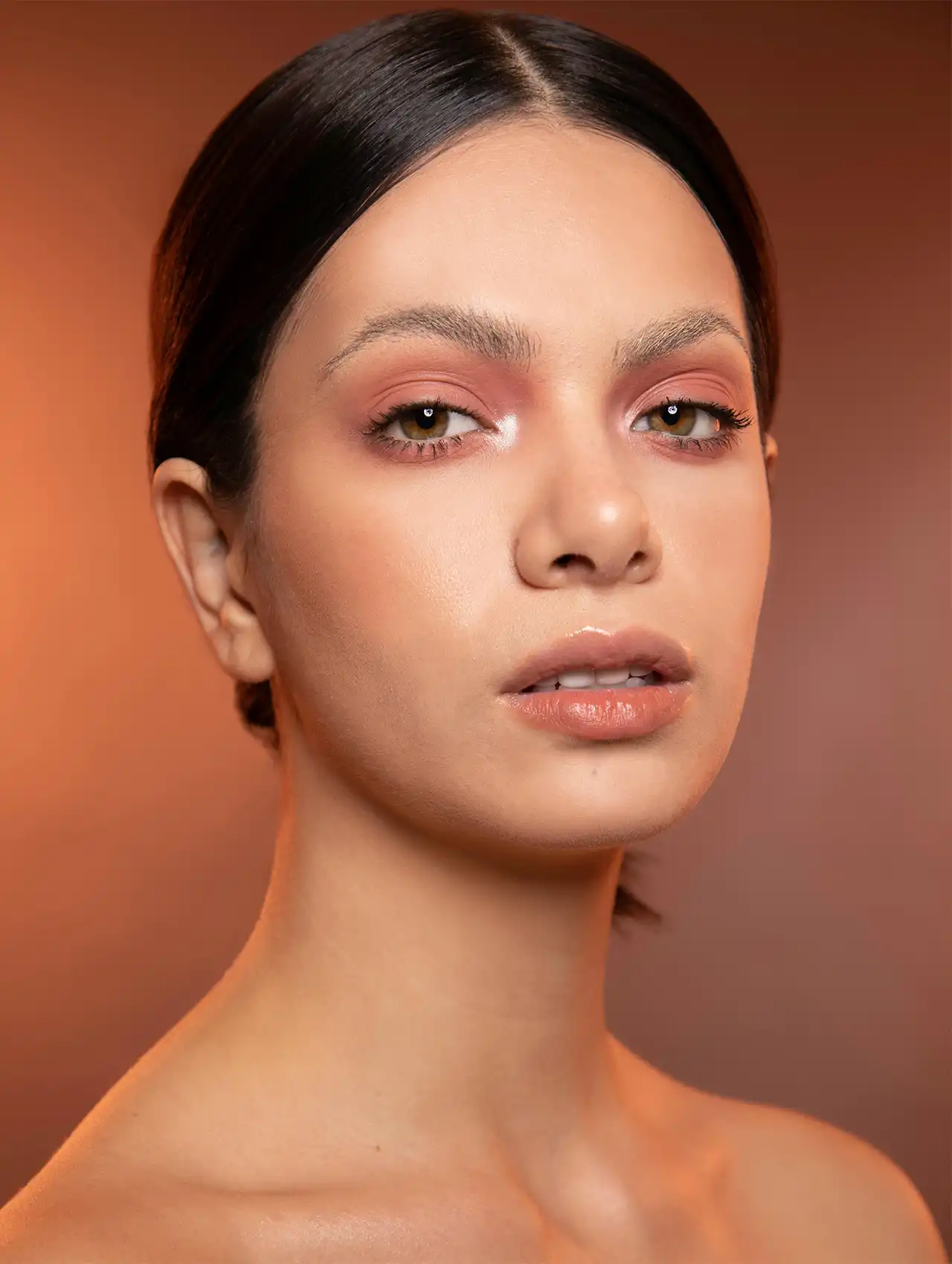 Rostro con piel luminosa y maquillaje natural con brillos