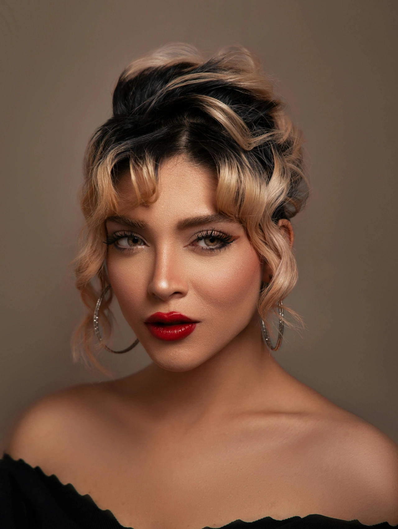 Close-up portrait of a woman wearing bold red lipstick and glam look — perfect Thanksgiving makeup idea.