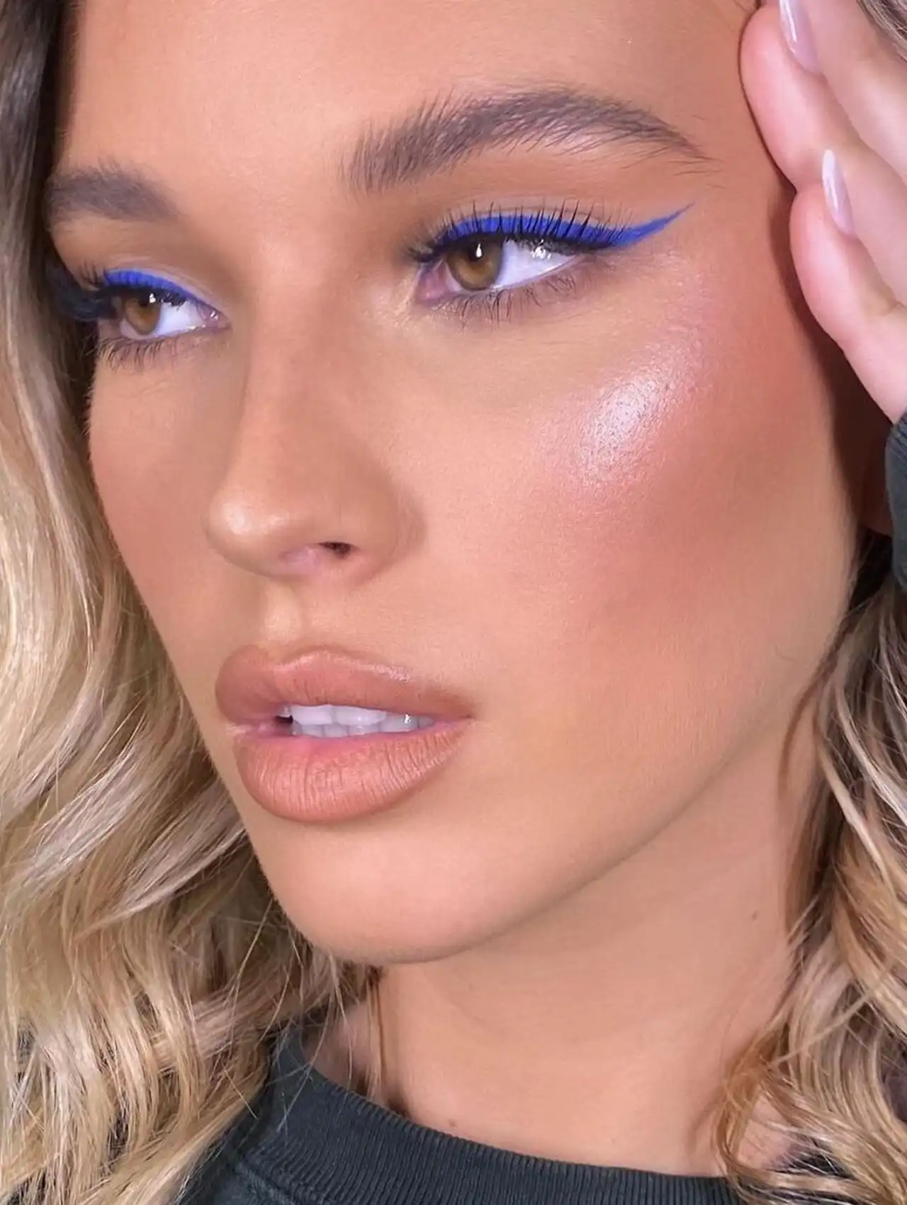 Mujer luciendo un delineado clásico y definido con delineador de ojos azul intenso.
