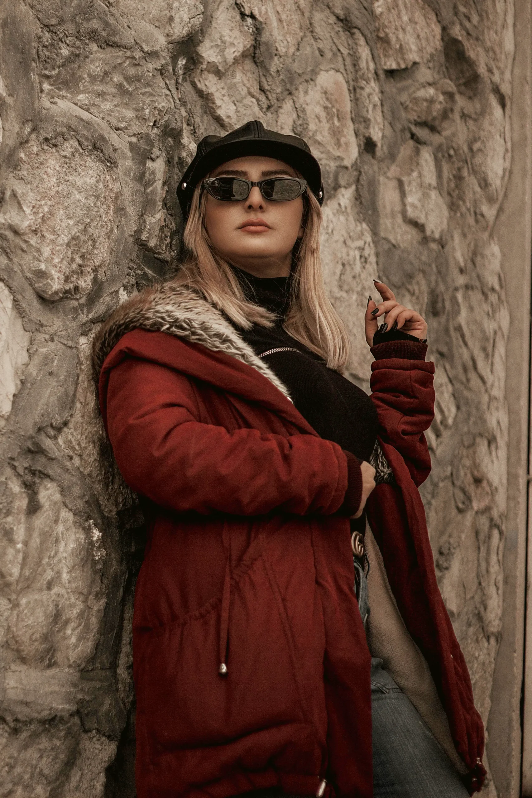Woman wearing a red fur-trimmed parka styled as trendy fall jackets.