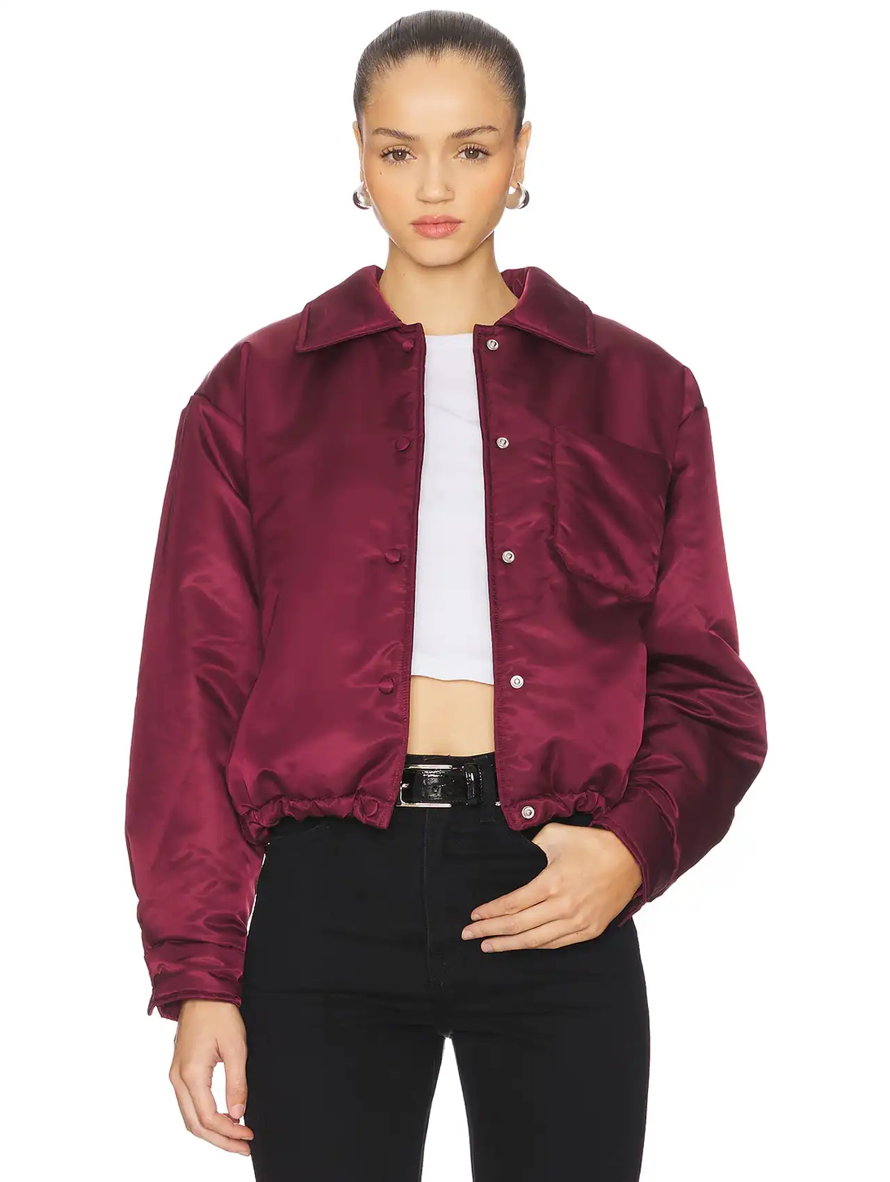 Woman wearing a burgundy satin bomber jacket styled as trendy fall jackets.