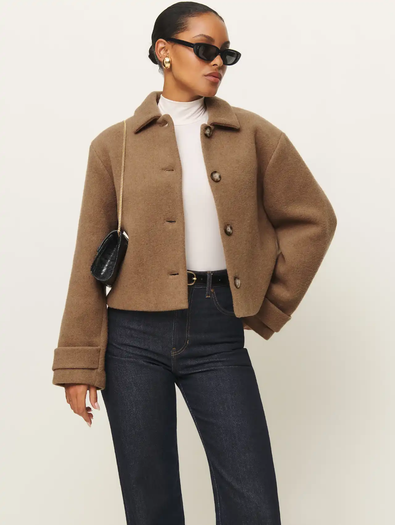 Woman in a brown cropped jacket and dark jeans for chic fashion inspiration