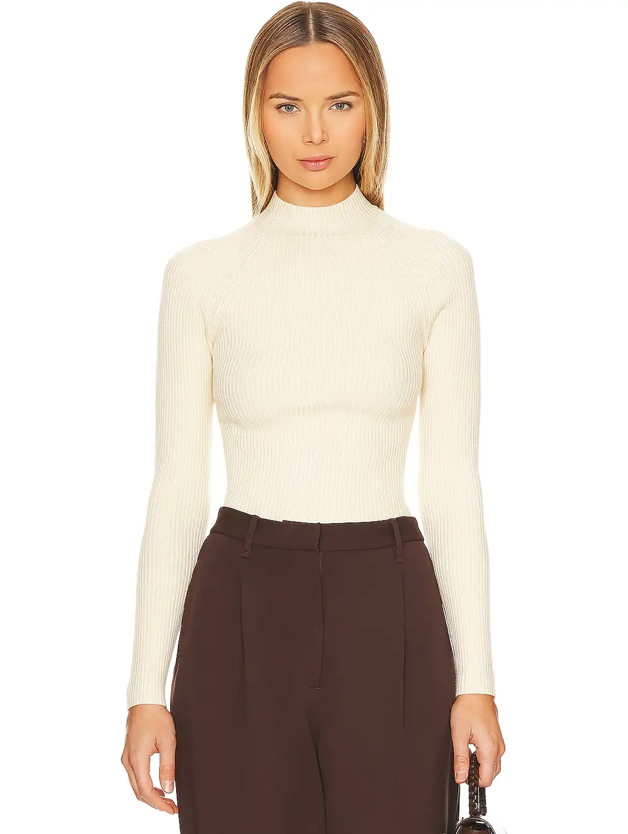 Woman in a fitted cream knit top styled for minimal fashion inspiration