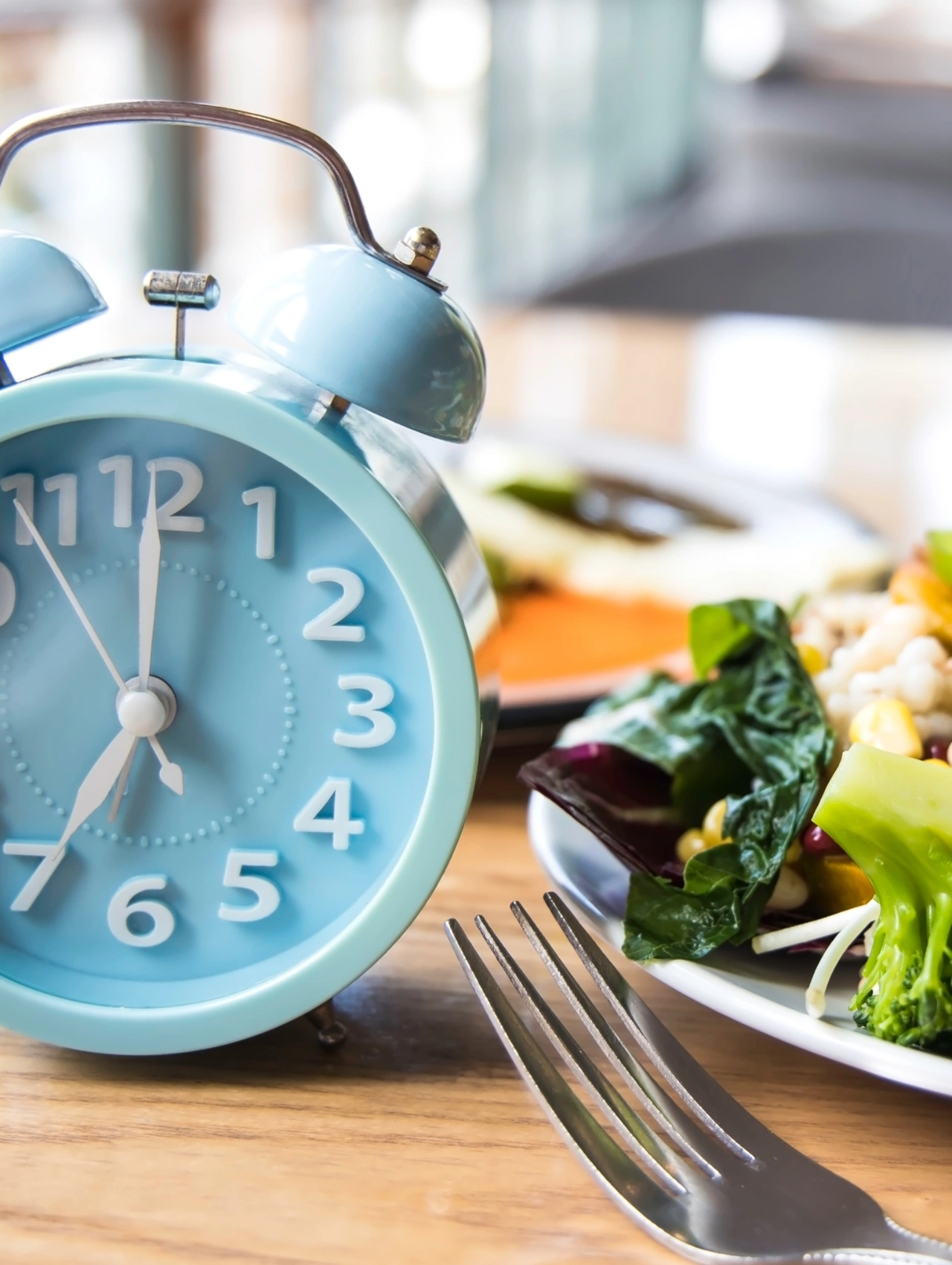 8 tips to get great intermittent fasting results shown with a clock next to a healthy meal on a table.