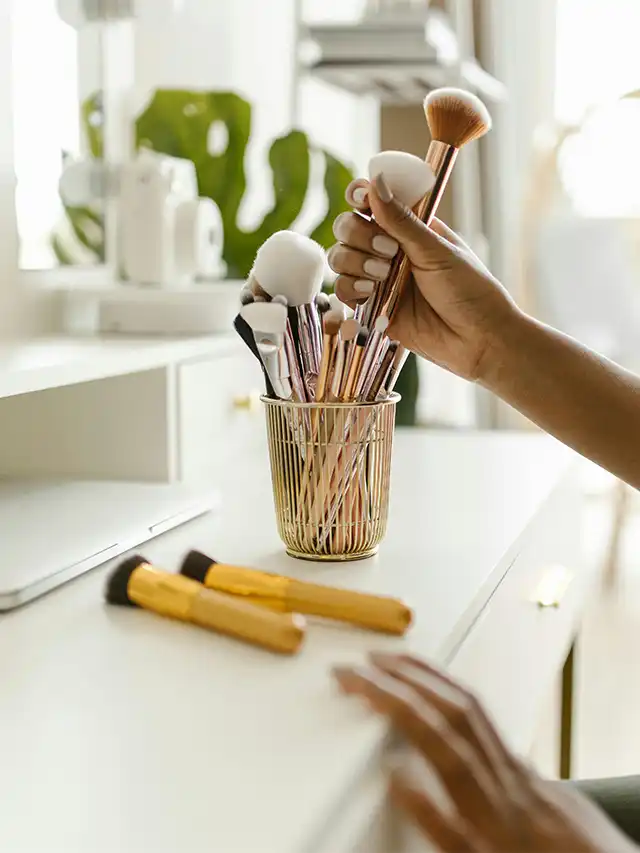 a hand holding a set of makeup brushes