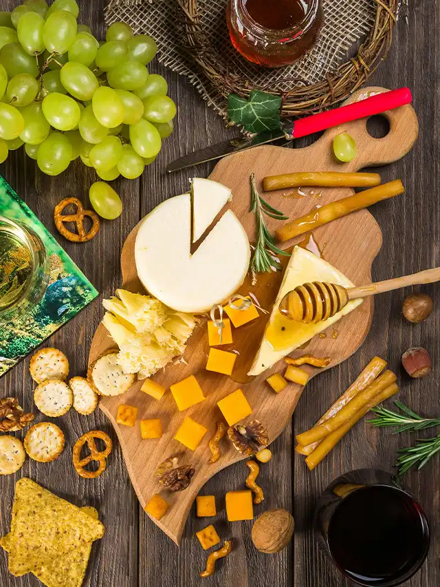 a cheese board with grapes and nuts