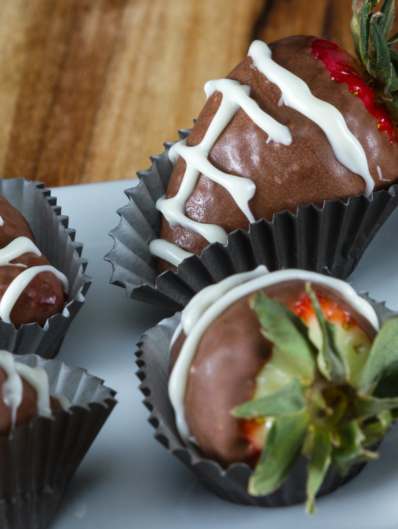 Chocolate football strawberries super bowl desserts with strawberries dipped in chocolate and decorated like footballs.