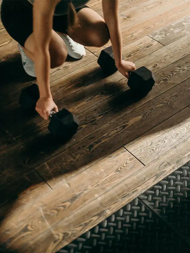 a person lifting weights on a wooden floor