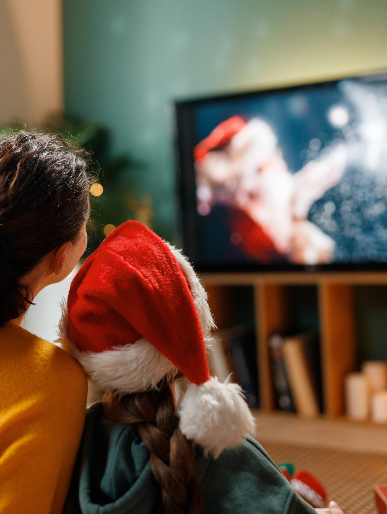 Mother and daughter watching a Christmas movie featuring Santa, illustrating magical moments created by New Christmas Movies