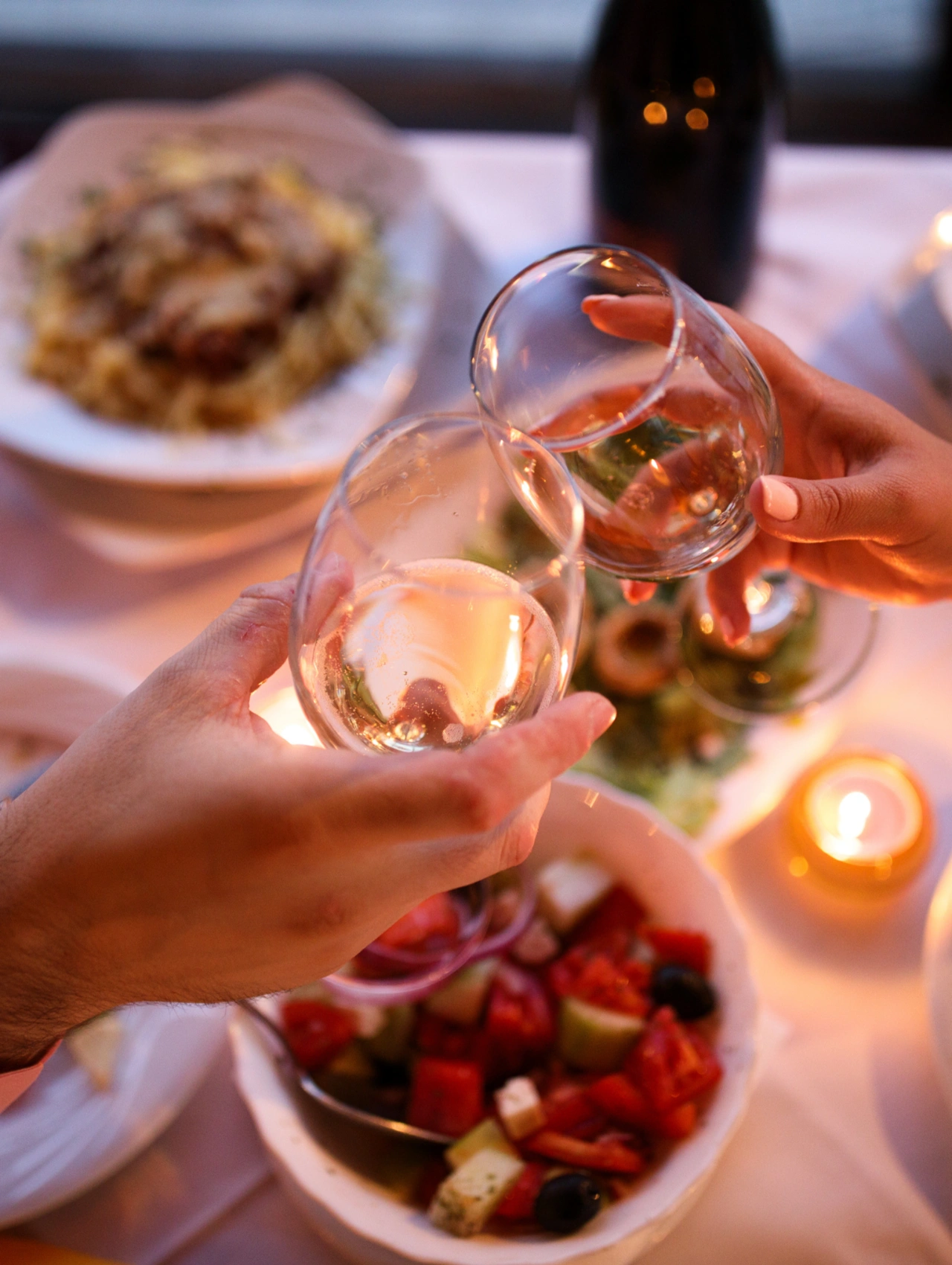 Romantic Grazing Platter for Two, hands toasting wine glasses over a shared table spread, modern romantic dinner ideas for couples